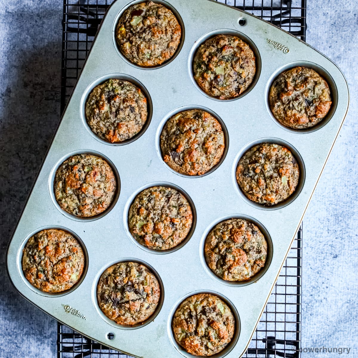 vegan almond flour muffins in a muffin tin on a cooling rack