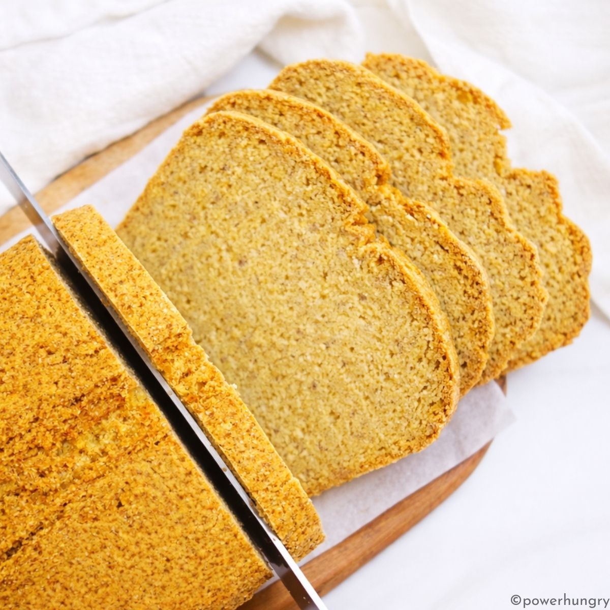 cooled chickpea bread getting sliced on cutting board