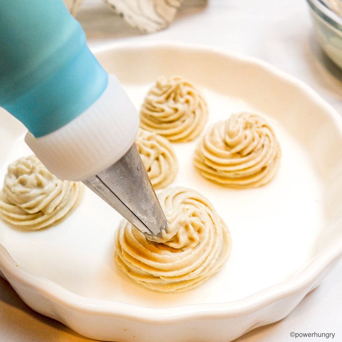 piped cashew whipped cream on a white plate