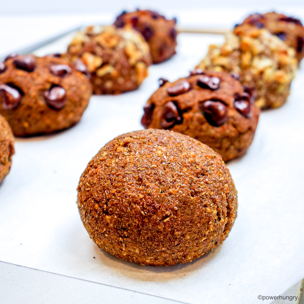 Banana lentil bread rolls on a white parchment paper lined baking sheet