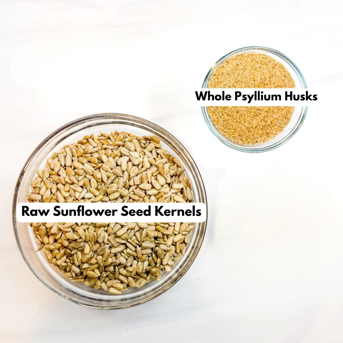 two glass bowls, one filled with psyllium husks, the other with sunflower seeds.