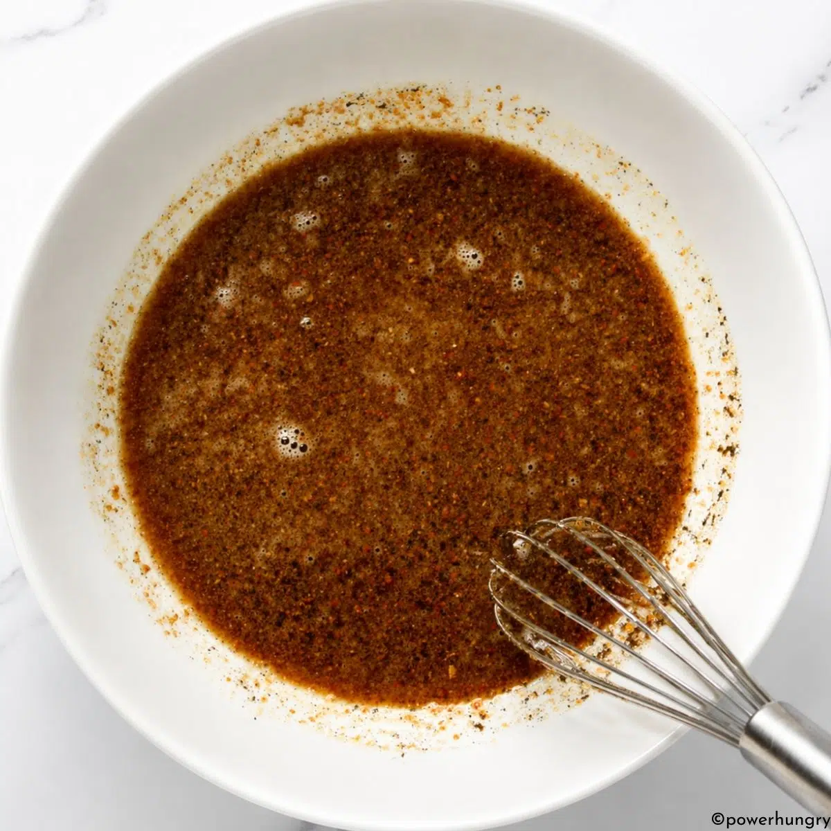 wet ingredients, whisked in a white bowl, for vegan carob almond flour brownies