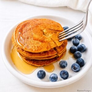red lentil pancakes on a white plate with blueberries